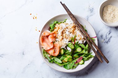 Salata - pirinç ve salatalıklı somon, beyaz mermer kraker bahçesi, üst manzara.