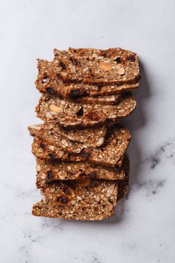 Beyaz mermer arka planda dilimlenmiş fındık ve tohum ekmeği..