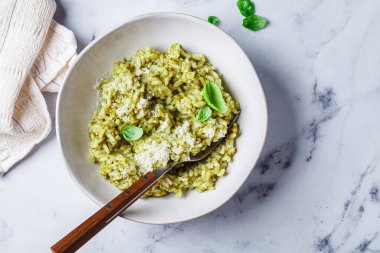 Parmesanlı yeşil pesto risotto, beyaz mermer arka plan, üst manzara..