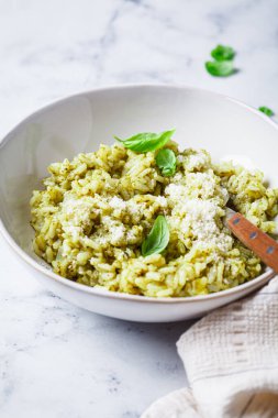 Parmesanlı yeşil pesto risotto, beyaz mermer arka plan..