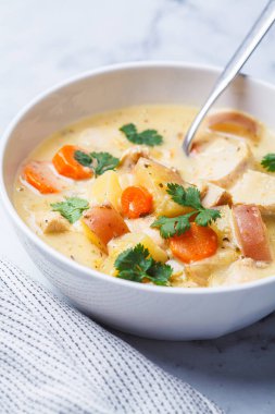 Beyaz kasede patates ve havuçlu tavuk göğsü güveci. Rahatlatıcı gıda konsepti.