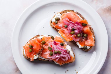 Krem peynirli somon tostu, turşulu kırmızı soğan ve kapari..