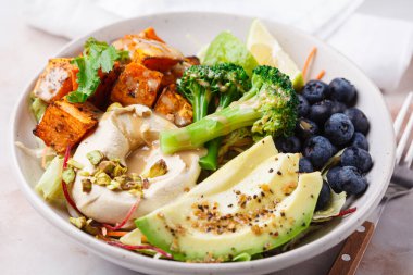 Tatlı patates, avokado, böğürtlen, salata ve humus ile dengeli vejetaryen yemek kasesi. Bitki Temelli Diyet Konsepti.