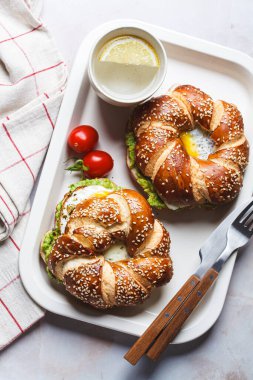 Beyaz tabakta yumurta ve avokado soslu kahvaltı çöreği..