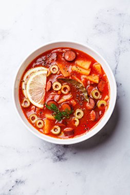 Geleneksel domates çorbası solyanka füme sosis, zeytin ve patates, üst manzara.