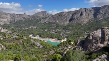 İspanya 'nın Alicante kentindeki yeşil çam ormanları ve kayalık dağlarla çevrili Guadalest Vadisi' nin insansız hava aracı görüntüsü. Güneşli bir günde manzaralı doğal manzara.