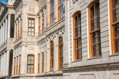 Dolmabahce Palace exterior with columns and architectural details. Grand Ottoman palace or saray facade architecture in Istanbul, Turkey. Baroque architectural columns, arched windows and stone detail