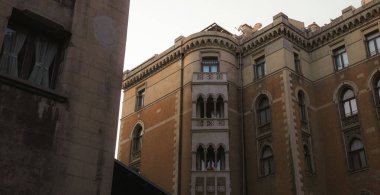 Historic gothic architecture in courtyard of Saint Anthony of Padua Church, Istanbul. Old European style facade with decorative arches and balcony. Landmark in Beyoglu district with sunset light