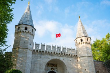 Istabul, Turkey - August 26 2025: Grand entrance of Topkapi Palace with towers and Turkish flag under blue sky. Gate of salutation. Historic Ottoman architecture, Landmark