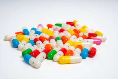 İzole edilmiş beyaz arka planda rengarenk ilaç kapsülleri, canlı ilaç çeşitleri. Renkli hapları etrafa saçın. Sağlık, ilaç, sağlık, tedavi ve çeşitlilik kavramı