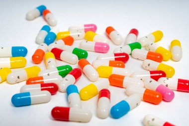 İzole edilmiş beyaz arka planda rengarenk ilaç kapsülleri, canlı ilaç çeşitleri. Renkli hapları etrafa saçın. Sağlık, ilaç, sağlık, tedavi ve çeşitlilik kavramı