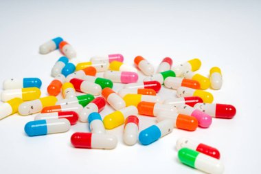 İzole edilmiş beyaz arka planda rengarenk ilaç kapsülleri, canlı ilaç çeşitleri. Renkli hapları etrafa saçın. Sağlık, ilaç, sağlık, tedavi ve çeşitlilik kavramı