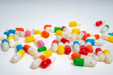 İzole edilmiş beyaz arka planda rengarenk ilaç kapsülleri, canlı ilaç çeşitleri. Renkli hapları etrafa saçın. Sağlık, ilaç, sağlık, tedavi ve çeşitlilik kavramı