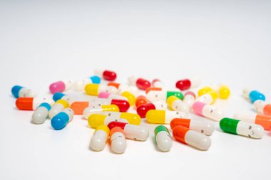 İzole edilmiş beyaz arka planda rengarenk ilaç kapsülleri, canlı ilaç çeşitleri. Renkli hapları etrafa saçın. Sağlık, ilaç, sağlık, tedavi ve çeşitlilik kavramı