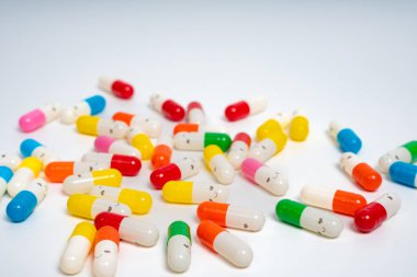 İzole edilmiş beyaz arka planda rengarenk ilaç kapsülleri, canlı ilaç çeşitleri. Renkli hapları etrafa saçın. Sağlık, ilaç, sağlık, tedavi ve çeşitlilik kavramı