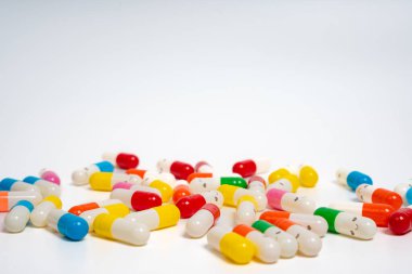İzole edilmiş beyaz arka planda rengarenk ilaç kapsülleri, canlı ilaç çeşitleri. Renkli hapları etrafa saçın. Sağlık, ilaç, sağlık, tedavi ve çeşitlilik kavramı