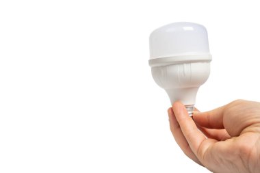 Hand holding white LED bulb on isolated white background, modern lighting. Close up view of LED bulb in hand. Energy efficient, technology, illumination and innovation concept