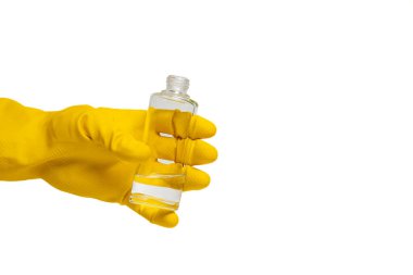 Hand in yellow glove holding clear liquid bottle on isolated white background. Close-up view of transparent bottles. Hygiene, safety, and cleanliness concept