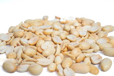 Beyaz arka planda izole edilmiş yakın plan kabuklu ve yarı yarıya fıstık yığını. Atıştırmak ve pişirmek için kabuklu yerfıstığı yığını