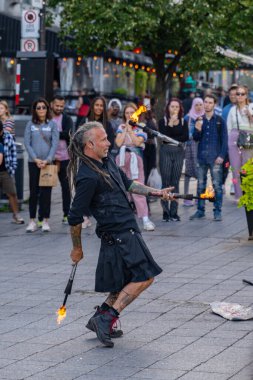 Montreal, Canada - September 4, 2022: Street performance, young juggler and acrobat entertain people in the heart of Montreal downtown street, Pl. Jacques-Cartier. High quality photo.