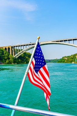 Amerikan bayrağı ve Niagara Nehri üzerindeki Gökkuşağı Köprüsü. Amerika Birleşik Devletleri ile Kanada 'yı birbirine bağlayan kemer köprüsü. Yüksek kalite fotoğraf.