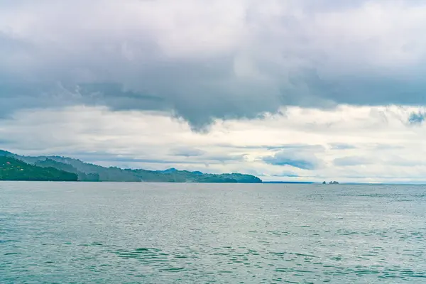 トランキル海水は熱帯の海岸線の前に 評判の良い丘の上に雲が降りてきます 高品質の写真 コスタリカ コスタリカ ストックフォト