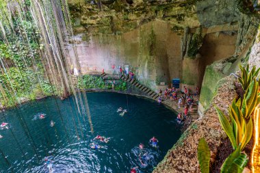 Ik Kil Cenote, Meksika - 2 Ocak 2022 Chichen Itza, kristal berraklığında turkuaz suyla çevrili doğal havuzun keyfini çıkaran yüzücülerle dolu sersemletici bir sandık.