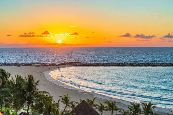Sakin Karayip Denizi 'nde altın gün doğumu. Palmiye ağaçları ve Cancuns Hotel Zone' da kumlu plajlar. Meksika yüksek kaliteli fotoğraf..
