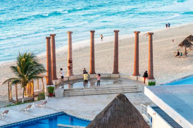 Cancun, Meksika - 6 Ocak 2022: Cancun 'da kıyı şeridinin ve okyanus manzarasının tadını çıkaran turistler, arka planda yüksek kaliteli bir fotoğraf ile bir tatil havuzu ve turkuaz dalgaları ile.