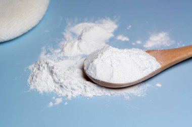 Ucunda az miktarda beyaz toz olan bir parmak, aynı tozdan bir kabın üzerinde asılı duruyor..