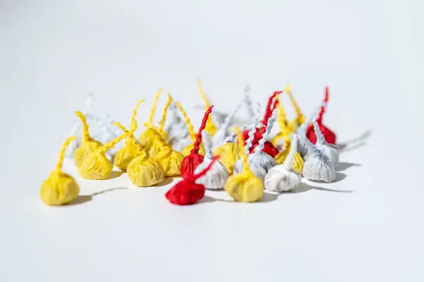 A pile of small, colorful firecrackers, commonly known as Pop-Pops or snappers, lying on a plain white background.