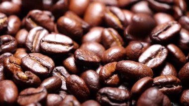 Kahve çekirdekleri yavaş düşüyor. Yüksek kalite süper yavaş kahve çekirdekleri siyah masaya düşüyor.