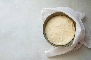 Metal kasede yükselen hamur mayası manzarası. Pizza, Focaccia ya da ekmek için hazır. Parlak, doğal, taştan bir tezgahta. Metin için yeri var. Üst görünüm