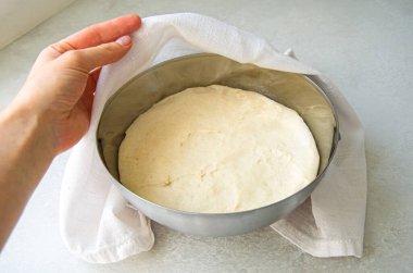 Pizza, Focaccia ya da ekmek için ne kadar maya hamuru yetiştiğini kontrol eden bir kadın. Parlak bir mutfakta metal bir kasenin içindeki hamura dokunmak ve çıkarmak..