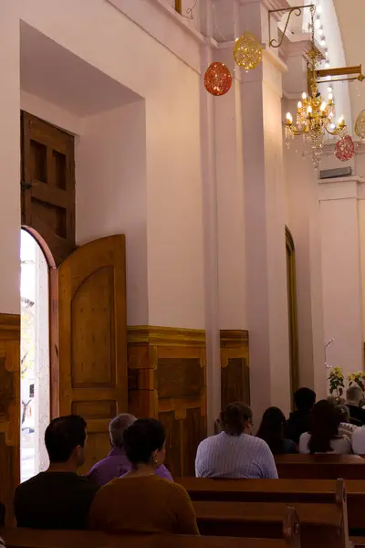 Küçük bir katolik kilisesinde (Seor de la misericordia chapel) noel süslemeleri ile yapılan dini tören sırasında insanlar otururlar.