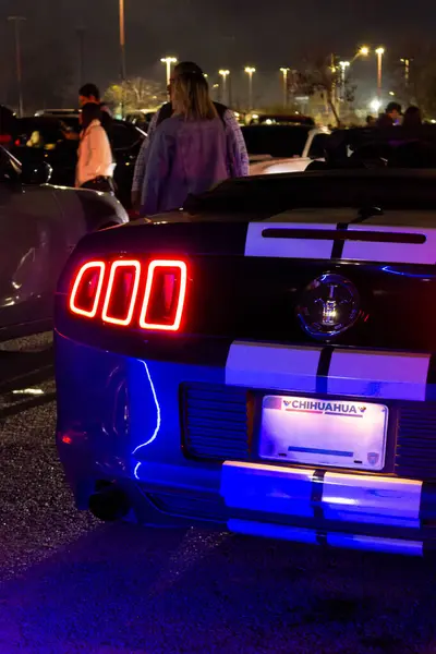 Park yerindeki bir araba toplantısında mavi Mustang neon lambaları.
