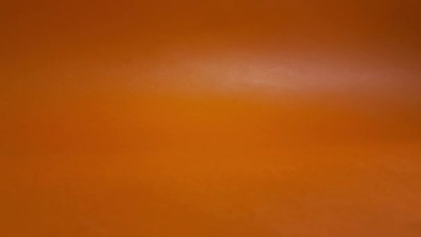 オレンジ色の背景に白紙を見せる男の手 事業概念 — ストック動画