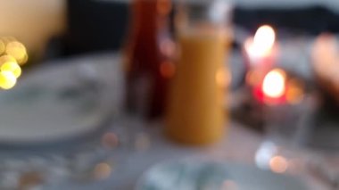 Kutlama masasının arka planındaki bulanık tatil partisi tabakları, mum ışıkları ve dekorasyonları. Bokeh etkisi. Yeni yıl, Noel, düğün, sevgililer günü veya doğum günü partisi konsepti