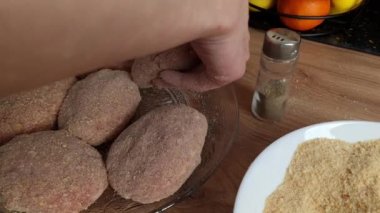 Kadın et parçalarını tabağa koyuyor. Akşam yemeği hazırlama, yemek pişirme, ev yapımı mutfak konsepti.