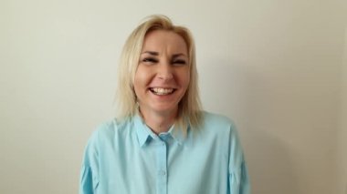 Happy smiling positive woman on gray background. Positive emotions concept