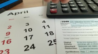Tax payment day marked on a calendar - April 18, 2023 with 1040 form, financial concept