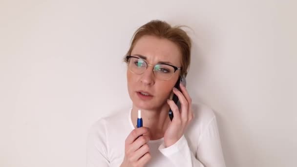 電子タバコを吸いながら眼鏡をかけ携帯電話で話す魅力的なブロンドの白人女性 ライフスタイルコンセプト — ストック動画