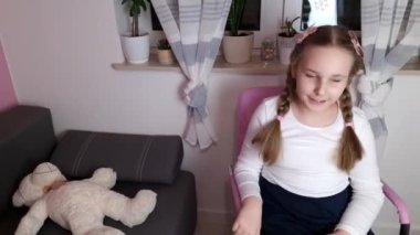 Evdeki sandalyede sallanan mutlu küçük kız. Çocukluk yaşam tarzı konsepti