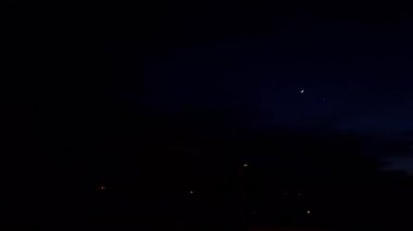 Beautiful night sky panorama with dark clouds, stars and the moon