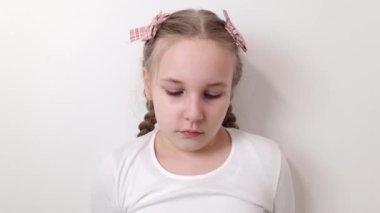 Sad stressed little girl expressing negative emotions, sorrow, bad mood. Female kid isolated on white background