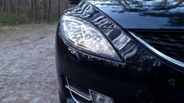 Czarne Nowoczesne Auto Zamyka Przednie Światło Samochód Zaparkowany Przy Leśnej — Wideo stockowe