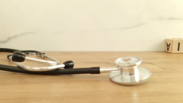 聴診器付き木製ブロックから作られた保険言葉 ヘルスケアの概念の背景 — ストック動画