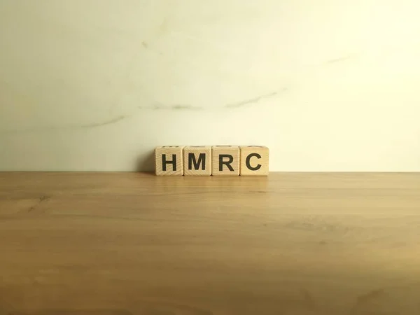 HMRC abbreviation from wooden blocks. Her Majestys Revenue and Customs UK tax authority concept
