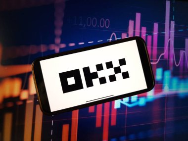 Konskie, Polonya - 05 Ocak 2024: OKX şifreleme döviz logosu şifreli pazar veri arkaplanındaki akıllı telefonda gösterildi