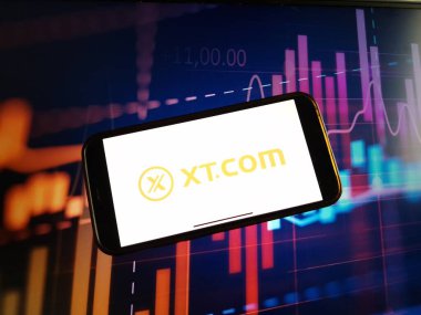 Konskie, Polonya - 05 Ocak 2024: XT.COM şifreleme döviz logosu şifreleme pazarının arka planında akıllı telefonda gösterildi